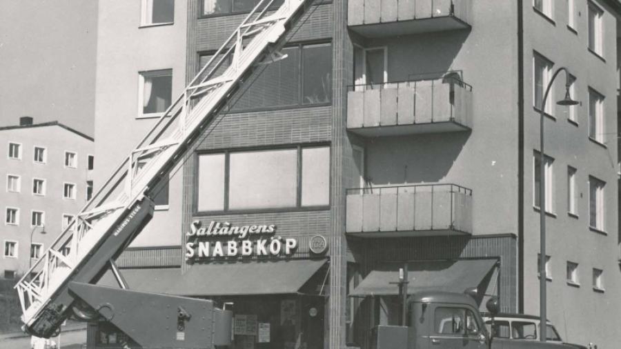 Nacka brandkår visar upp sin nya stegbil 1961. Saltängens Snabbköp låg på Saltängsvägen 24, huset känns ju igen. Fotograf okänd, Nacka Lokalhistoriska Arkiv.